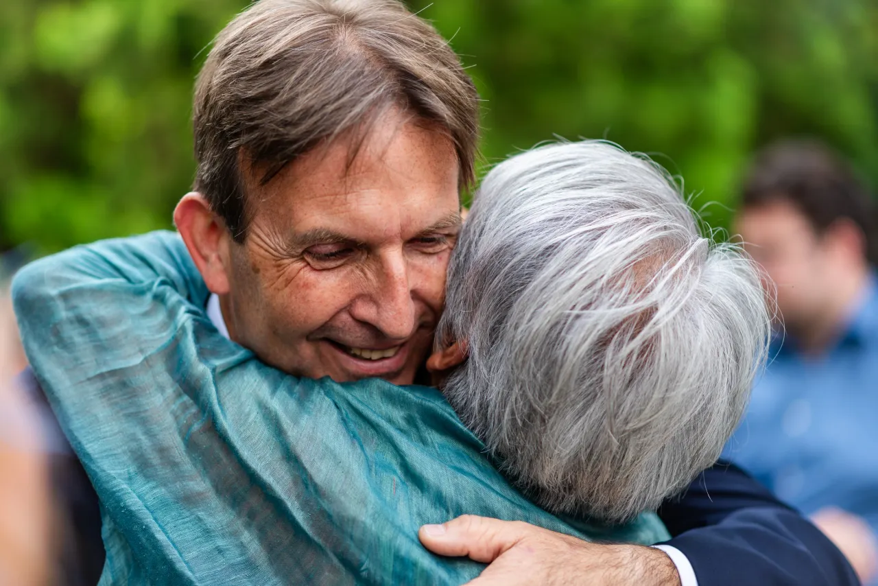 An embrace, with a smile visible over a shoulder