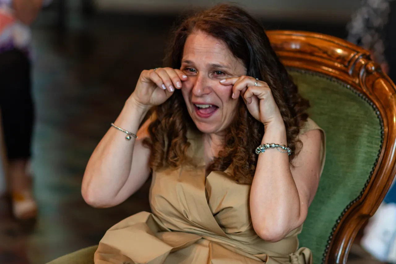 A tearful woman with her hands near her eyes