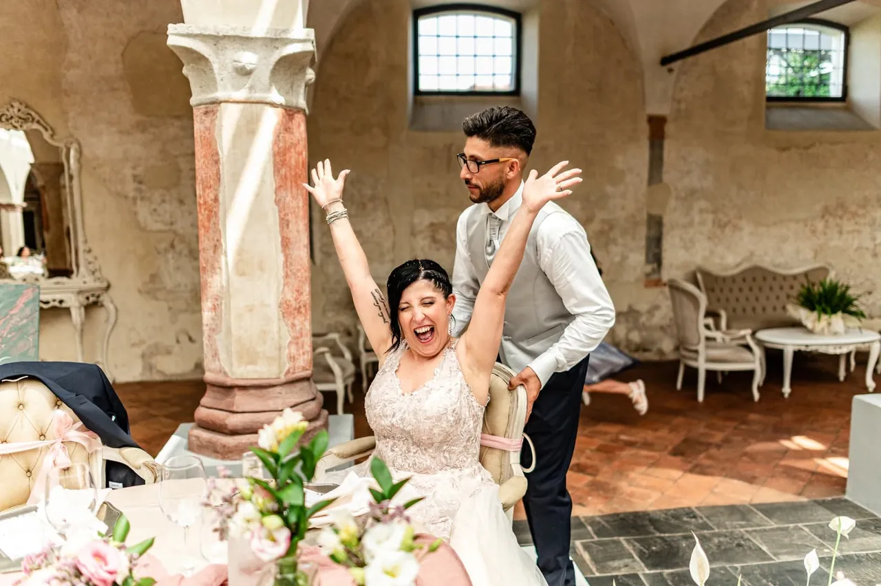 Alessandra raising her arms among the reception tables