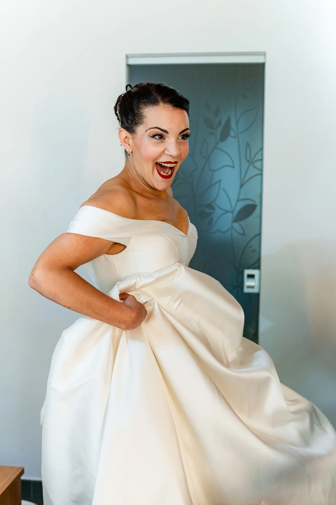 La sposa sorride tenendo la gonna dell’abito