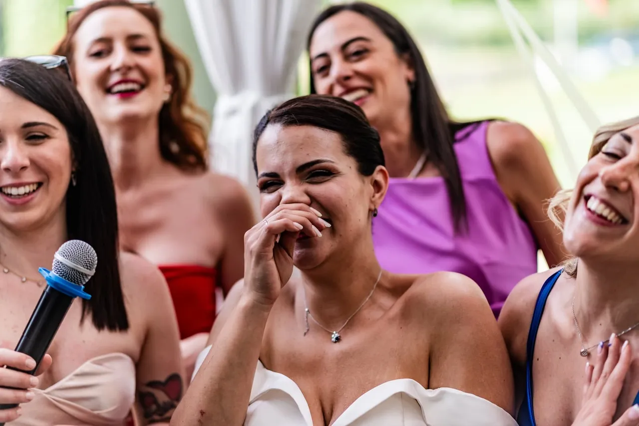 Laura laughing among guests at the reception