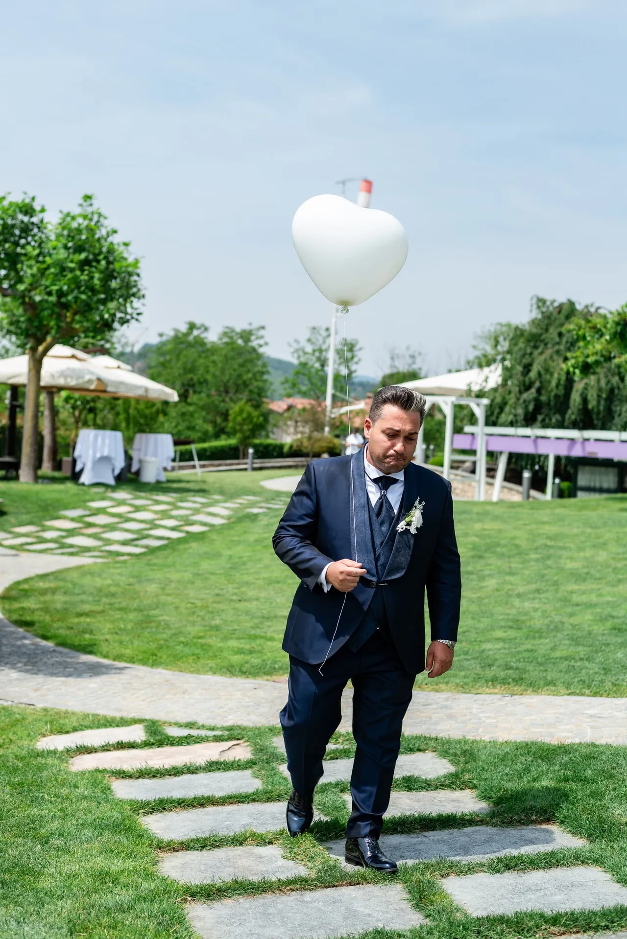 Davide cammina sul prato con il palloncino dedicato al ricordo di una persona cara