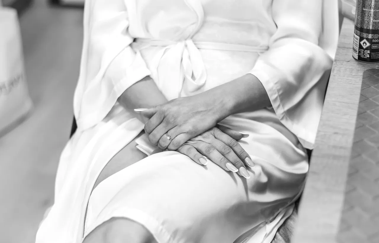 Le mani della sposa appoggiate sull’abito, in bianco e nero