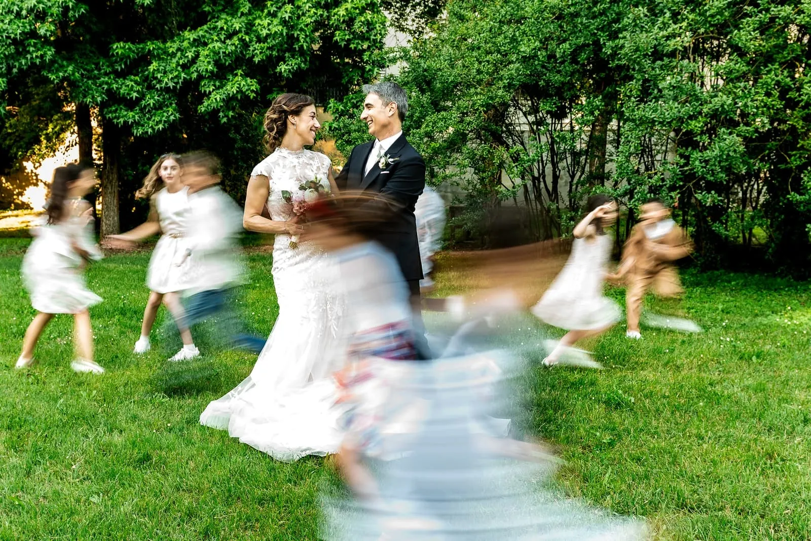 Veronica e Carlo sul prato, circondati da bambini in movimento