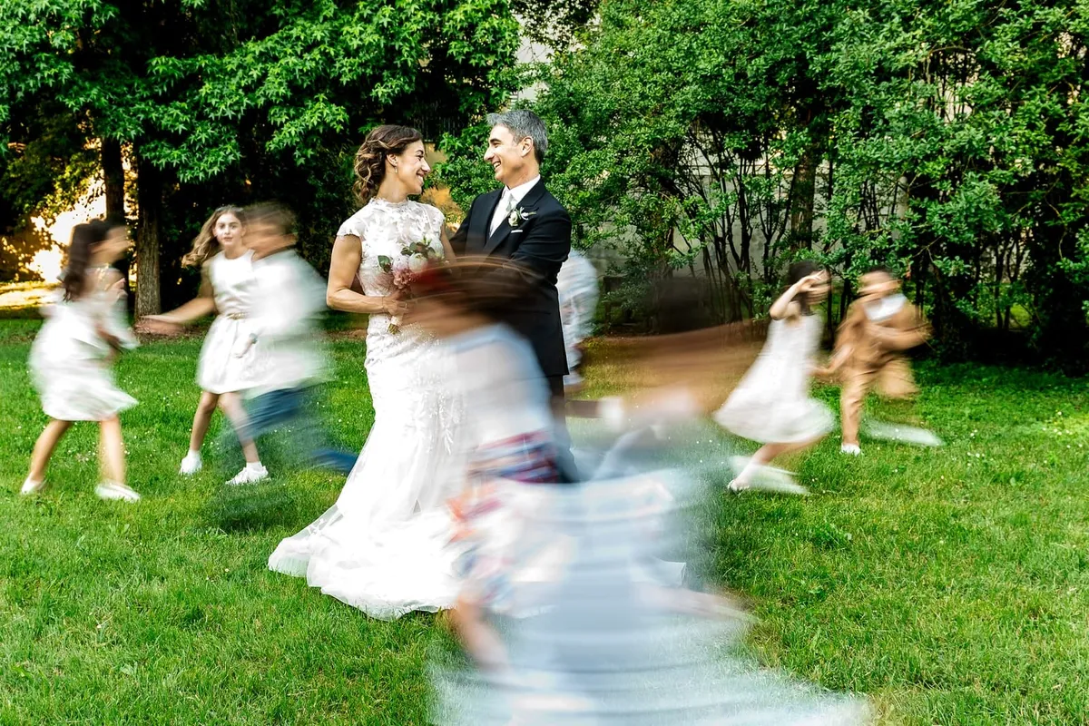 Veronica e Carlo sul prato, circondati da bambini in movimento