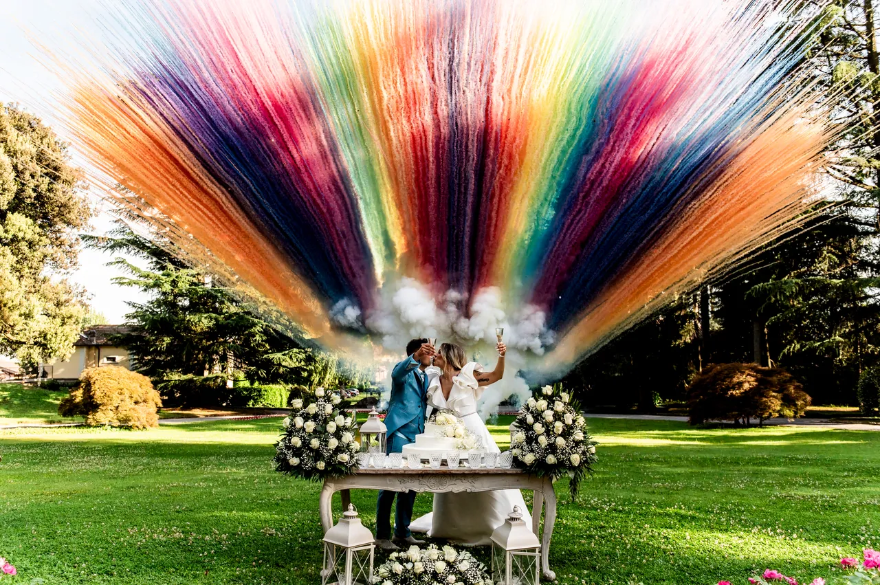 Nikla and Maurizio at their cake cutting surrounded by coloured smoke